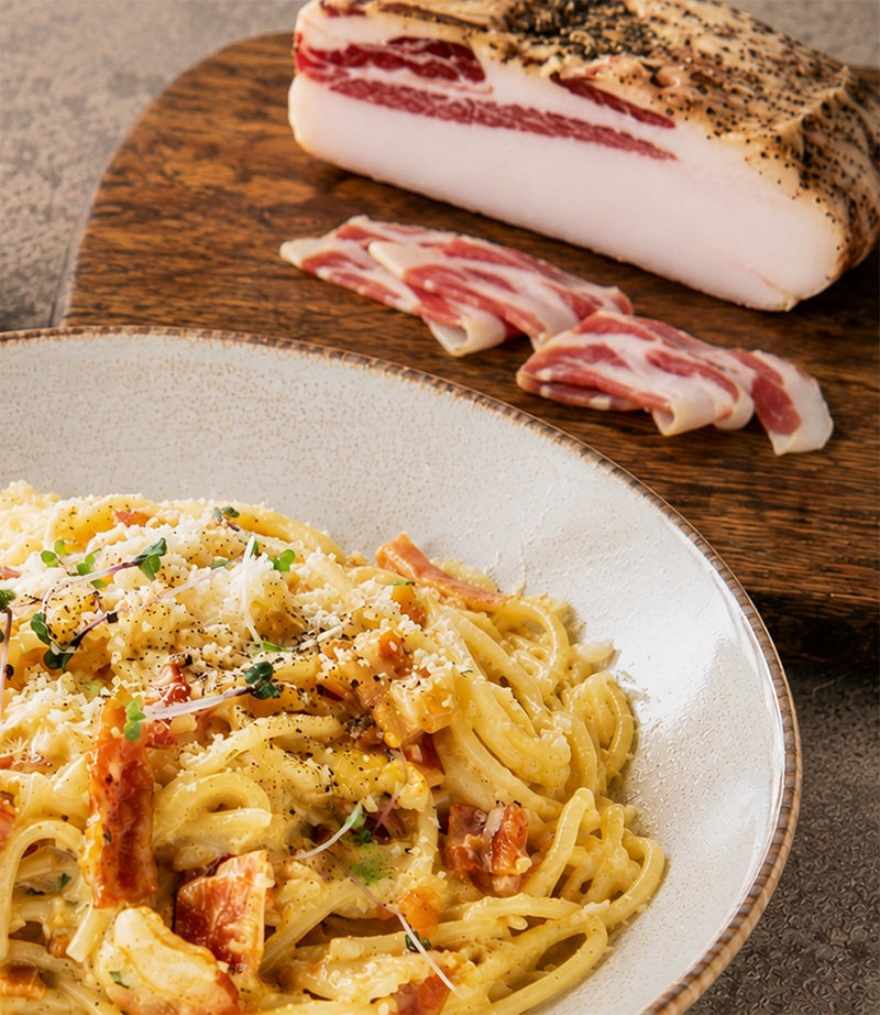 Pâtes carbonara traditionnelles avec guanciale croustillant et morceau de guanciale entier