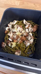 Poêlée campagnarde au airfryer avec pommes de terre dorées, champignons de Paris et haricots verts, servie chaude dans un plat rustique.