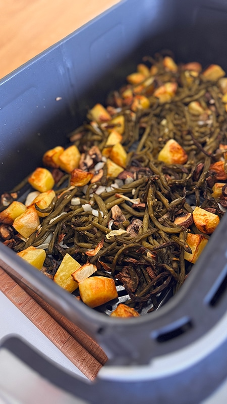 Poêlée campagnarde au airfryer avec pommes de terre dorées, champignons de Paris et haricots verts, servie chaude dans un plat rustique.