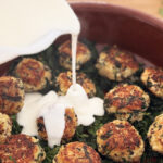 Boulettes de poulet au quinoa, épinards et béchamel légère gratinées dans un plat sain et équilibré, servies pour un dîner healthy sous 500 kcal.