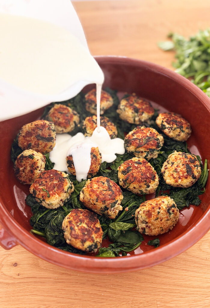 Boulettes de poulet au quinoa, épinards et béchamel légère gratinées dans un plat sain et équilibré, servies pour un dîner healthy sous 500 kcal.